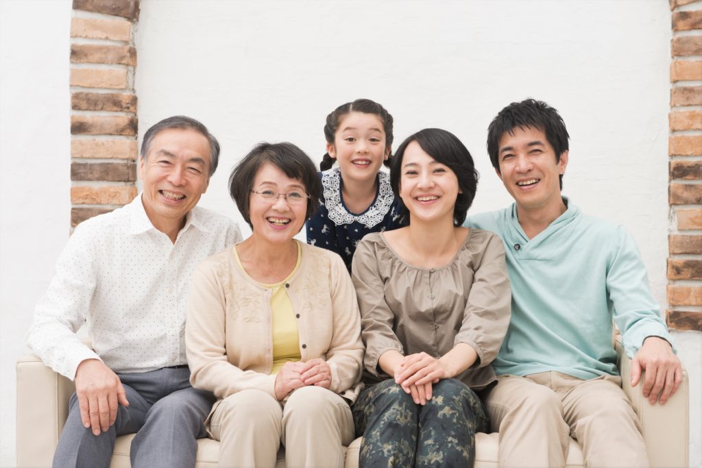 こちらに微笑みかけている三世代家族