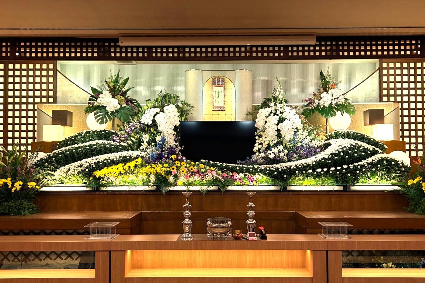 A funeral flower altar displayed in a large ceremony hall